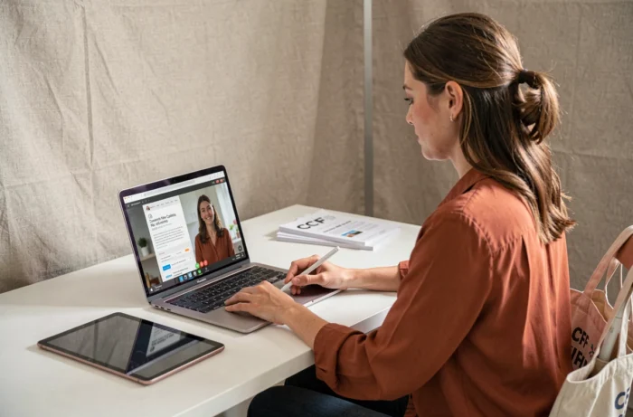 Jeune femme en formation Canva à distance via CPF pour apprendre à créer des newsletters percutantes