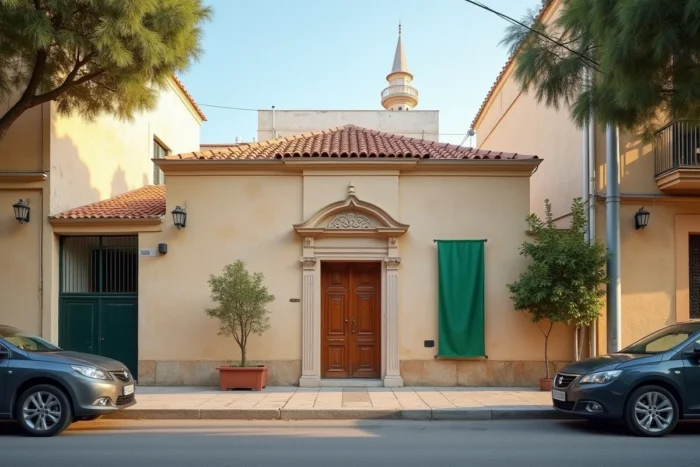 Façade d'une mosquée de quartier à Montpellier avec minaret et porte en bois sculptée dans une rue résidentielle